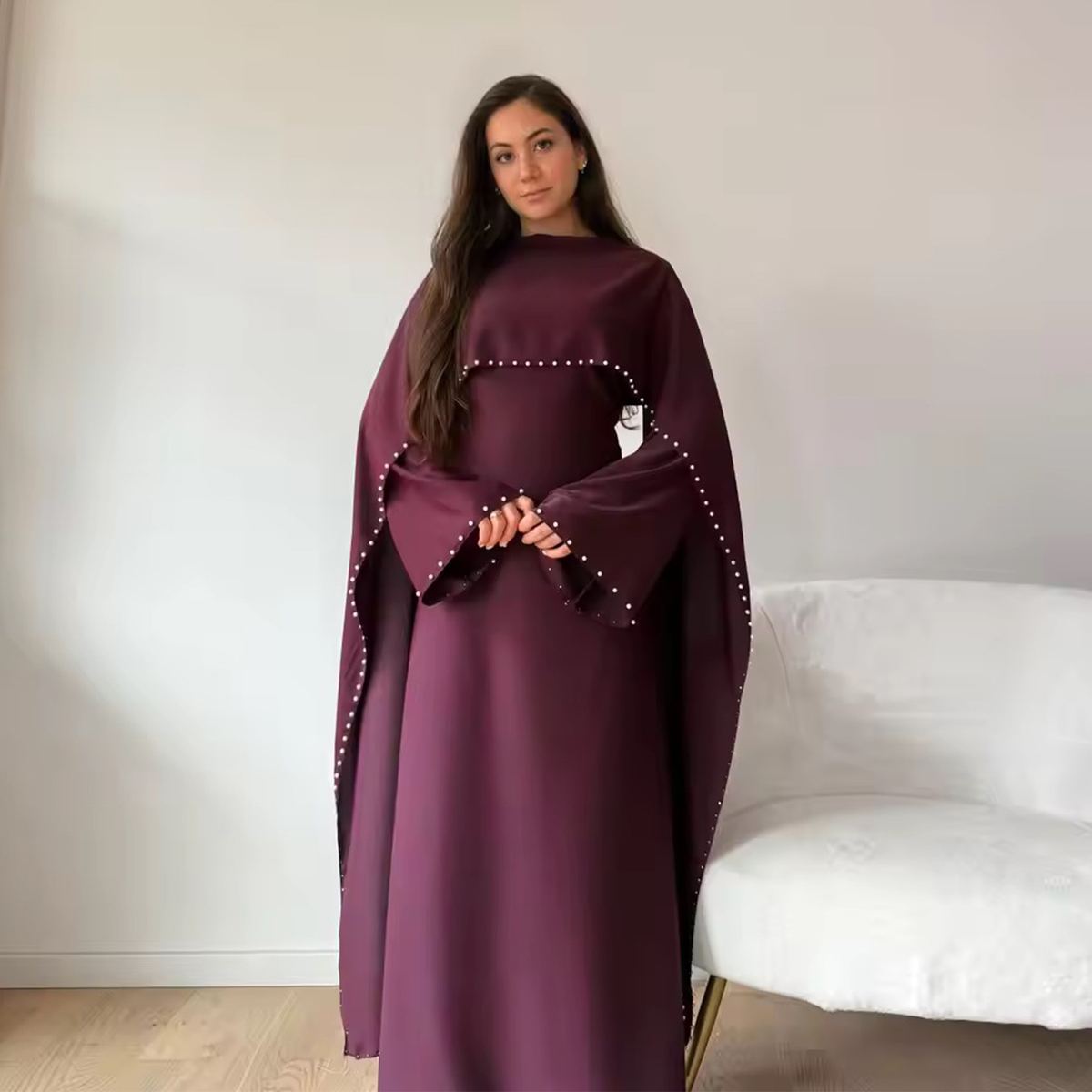Model in a pearl-beaded deep purple gown with matching cape