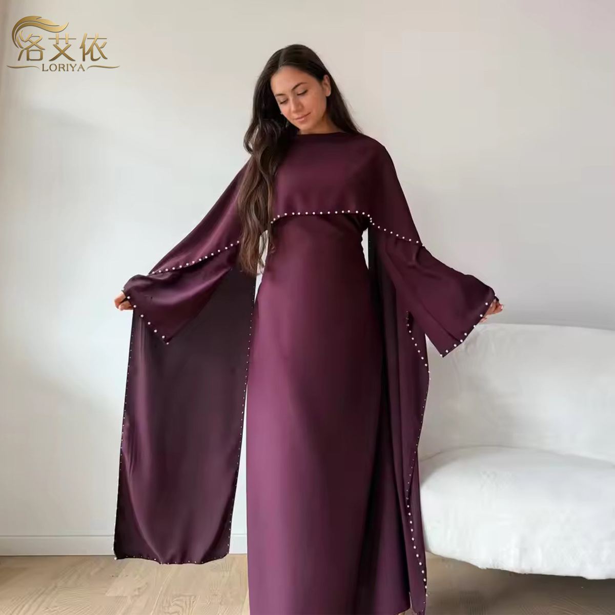 Model in a pearl-beaded deep purple gown with matching cape