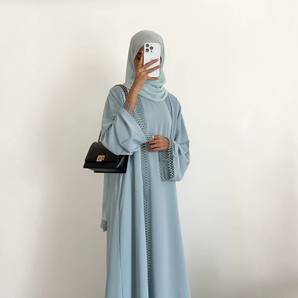 Model in a dusty-blue lace-trimmed cardigan over an inner dress