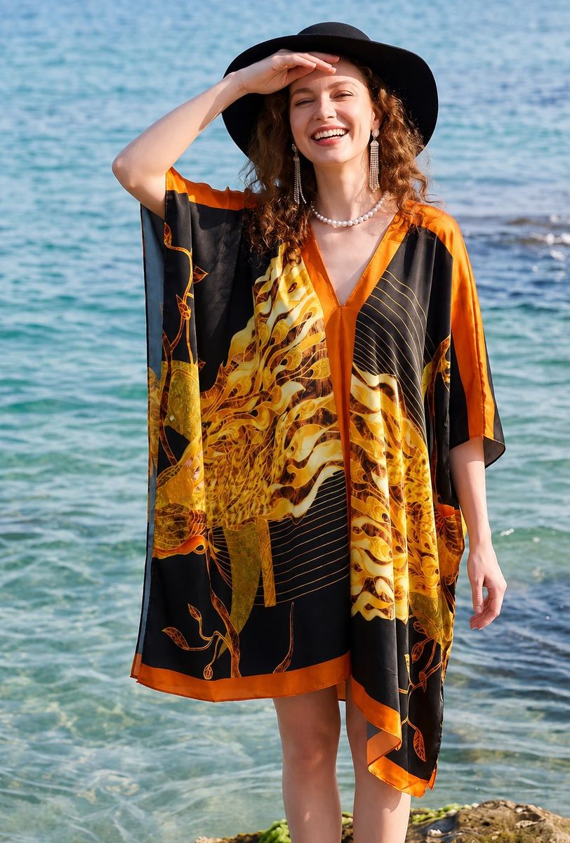 Plus-size V-neck kaftan maxi dress in black with gold feather print and orange edge