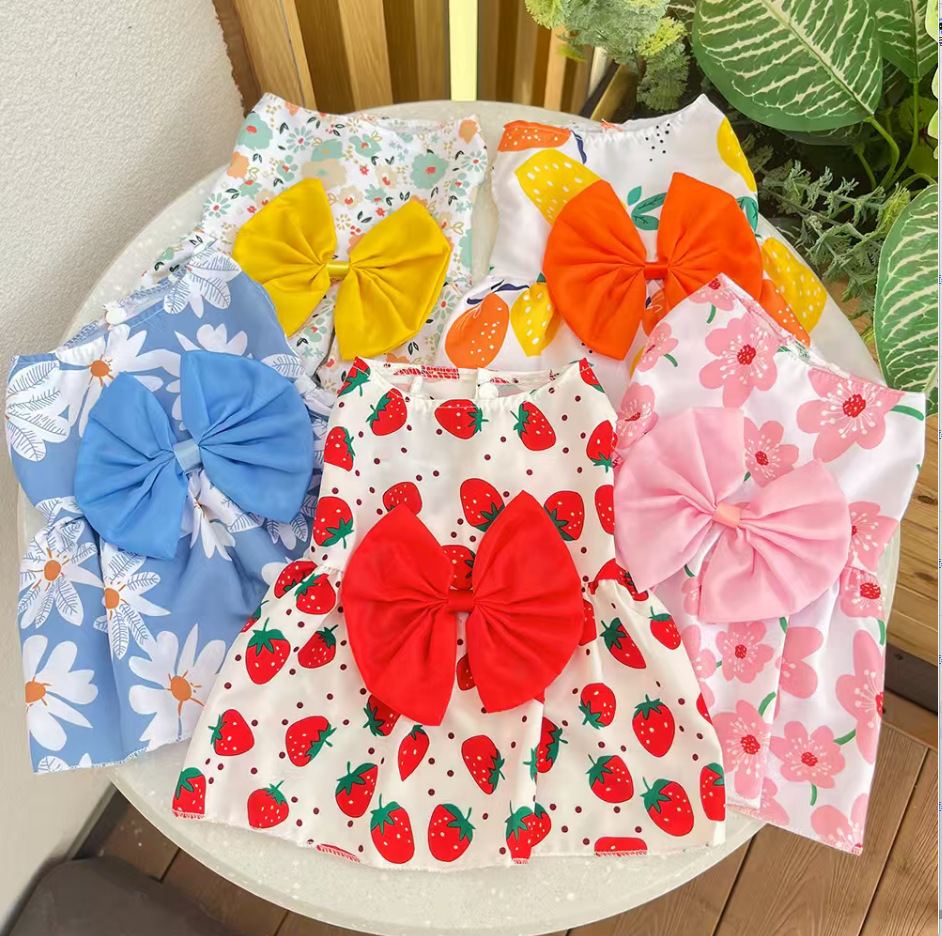 Five sleeveless printed dog dresses with bows in strawberry, daisy, floral and citrus patterns